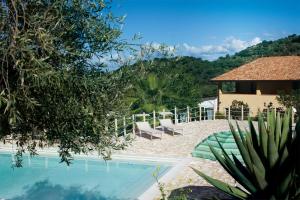 a resort with a pool and chairs and a building at Antica Tindari in Patti
