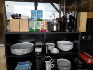a shelf filled with plates and cups and coffee at Almtalblick in Pettenbach +14 photos