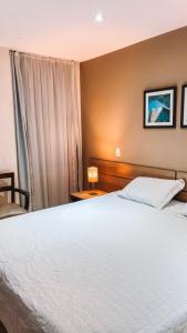 a bedroom with a white bed and a window at Apartamento em Duque de Caxias in Duque de Caxias +6 photos