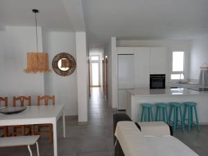 a kitchen and living room with a table and chairs at Caleta de Famara Casa acogedora y espaciosa in Famara +26 photos