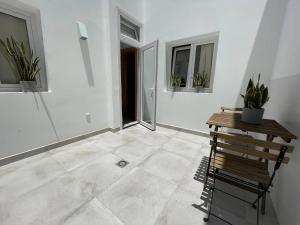 an empty room with a table and potted plants at Caleta de Famara Casa acogedora y espaciosa in Famara