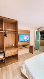 a bedroom with a bed and a television in a room at Apartamento em Duque de Caxias in Duque de Caxias