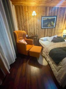 une chambre d'hôtel avec une chaise, un lit et un couvre-lit dans l'établissement Lee's Grandma's Will Cottage, à Kalimpong