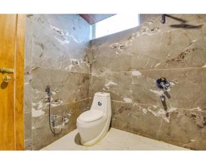 ein Badezimmer mit einer weißen Toilette in einem Zimmer in der Unterkunft HoTEL SIGNOR AIRPORT INDORE in Indore