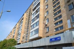 モスクワにあるLakshmi Great Apartment VDNHの青い看板が目の前に建つ高いレンガ造り