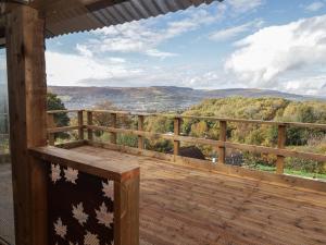 a wooden deck with a view of the mountains at Gwyn Studio in Aber-nant