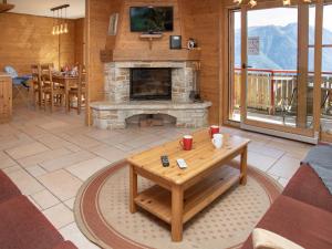 a living room with a fireplace and a table at Apartment Ardève 7 by Interhome in Ovronnaz +20 photos