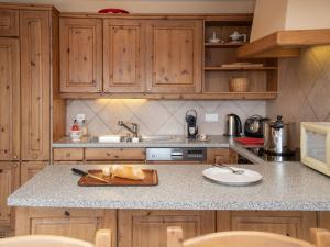a kitchen with wooden cabinets and a counter top at Apartment Ardève 7 by Interhome in Ovronnaz +28 photos