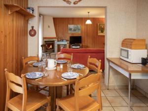 een keuken en eetkamer met een houten tafel en stoelen bij Apartment Roc Lyv by Interhome in Ovronnaz