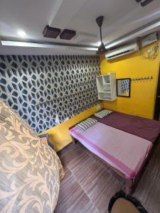 a small room with a bed and a yellow wall at Jsn Palace in Chennai