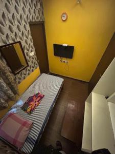 a small room with a bed and a tv at Jsn Palace in Chennai