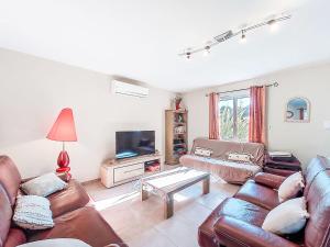 ein Wohnzimmer mit Ledersofas und einem TV in der Unterkunft Holiday Home Les Ormes by Interhome in Montalivet-les-Bains