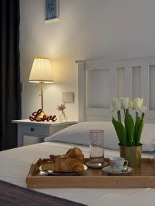 a tray of bread and flowers on a bed at L'obiettivo in Assemini