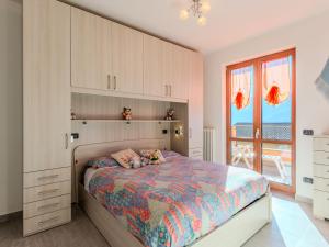 Un dormitorio con una cama y una ventana grande. en Apartment -1 by Interhome, en Gera Lario