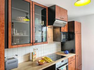 a kitchen with wooden cabinets and bananas on the counter at Holiday Home Bella by Interhome in Hohen Wieschendorf