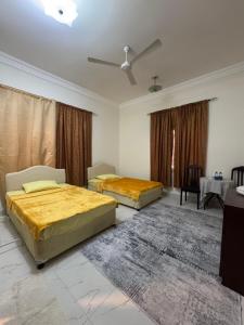 a bedroom with two beds and a table at Sultan Beach House in Muscat