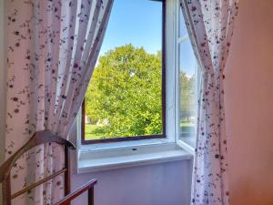 une fenêtre ouverte avec une chaise et un arbre dans l'établissement Holiday Home Ljudevit by Interhome, à Dobrinj