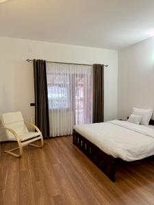 a bedroom with a bed and a chair and a window at Imperial in Moisei +23 photos