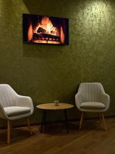a room with two chairs and a table and a fireplace at Imperial in Moisei