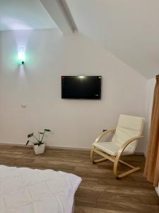 Habitación con silla y TV en la pared. en Imperial, en Moisei