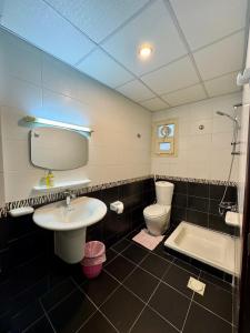 a bathroom with a sink and a toilet and a tub at Sultan Beach House in Muscat +33 photos