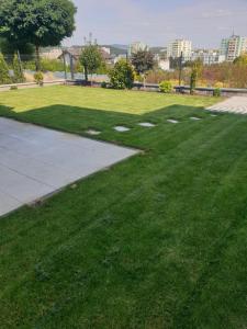 a park with green grass and a sidewalk at Apartmán na Kráľovej hore in Prešov