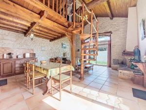 eine Küche mit einem Tisch und einer Holzdecke in der Unterkunft Holiday Home La Grange Jacques by Interhome in Dondas