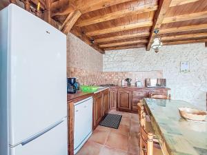 eine Küche mit Holzschränken und einem weißen Kühlschrank in der Unterkunft Holiday Home La Grange Jacques by Interhome in Dondas