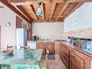 eine große Küche mit Holzschränken und einem Tisch in der Unterkunft Holiday Home La Grange Jacques by Interhome in Dondas + 18 Fotos