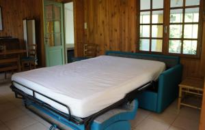 a bed in a room with wooden walls and windows at La Petite Pommerie in Chaumont-sur-Loire