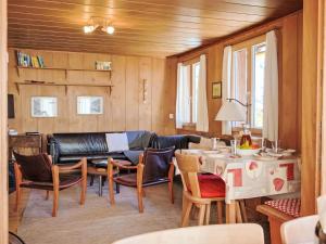 un soggiorno con un divano, un tavolo e delle sedie di Chalet Chalet Pitschun by Interhome a Grindelwald
