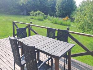 a wooden table and four chairs on a deck at Holiday Home Amlethus - 375m from the sea by Interhome in Allinge