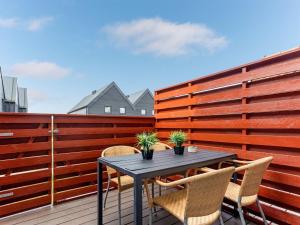 a table and chairs on a balcony with a fence at Holiday Home Alissa - 400m from the sea by Interhome in Fanø