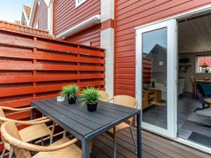 a patio with a table and chairs on a deck at Holiday Home Alissa - 400m from the sea by Interhome in Fanø +14 photos