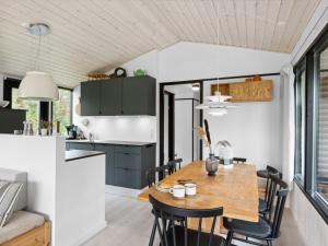 a kitchen and dining room with a wooden table and chairs at Holiday Home Shayene - 2-5km from the sea by Interhome in Læsø