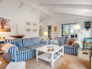 a living room with blue and white striped couches and a table at Holiday Home Danko - 1-5km from the sea by Interhome in Fanø