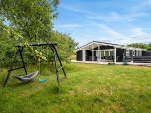 a hammock in a yard in front of a house at Holiday Home Bentine - 400m from the sea by Interhome in Fanø