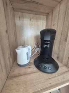a coffee maker and a coffeemaker sitting on a shelf at Chambre avec salle de bain privée in Saint-Gervais