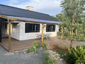a house with a wooden deck with a table at Holiday Home Alica - 200m from the sea by Interhome in Neksø +20 photos