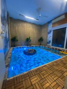a large swimming pool in a room with a blue ceiling at Jasmine Corner Chalet in Mawāliḩ