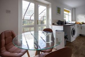 een glazen tafel en stoelen in een keuken bij Stanhope - Sizewell - Contractor Accommodation in Snape +7 foto's