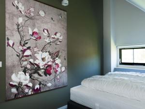 a painting of flowers on a wall next to a bed at Holiday Home Lethehuis by Interhome in Vlagtwedde +25 photos