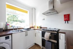 een keuken met een fornuis en een spoelbak bij Stanhope - Sizewell - Contractor Accommodation in Snape