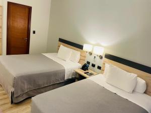 a hotel room with two beds and a door at Diego de Almagro Providencia Express in Santiago