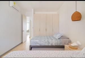ein Schlafzimmer mit zwei Betten und einer weißen Wand in der Unterkunft luxury apto sierra beach pozos colorados in Playa Bello Horizonte