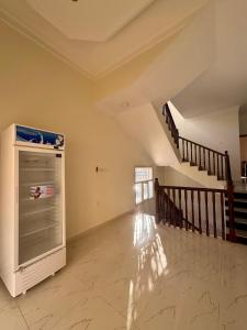 een lege kamer met een trap en een koelkast bij Sultan Beach House in Muscat