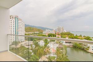 einen Balkon mit Blick auf das Wasser und die Gebäude in der Unterkunft luxury apto sierra beach pozos colorados in Playa Bello Horizonte