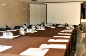 a conference room with tables and chairs and a screen at Le Lieu in Saint-Amour