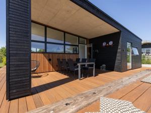 a wooden deck with a table and chairs on it at Holiday Home Karitte - 300m from the sea by Interhome in Hvidbjerg +24 photos