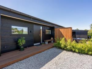a house with a wooden deck with a bench on it at Holiday Home Karitte - 300m from the sea by Interhome in Hvidbjerg